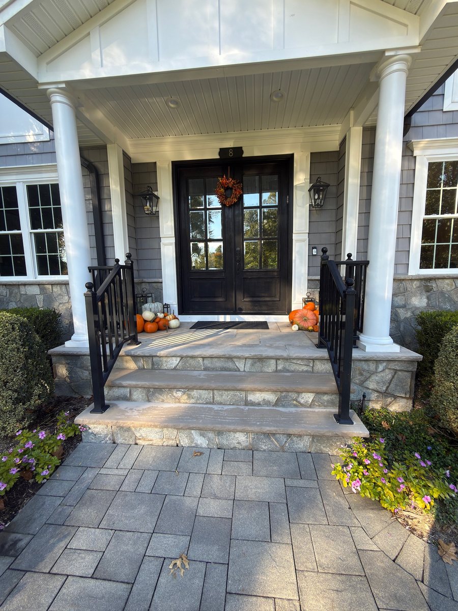 Front entrance with a walkway leading to a porch decorated with pumpkins