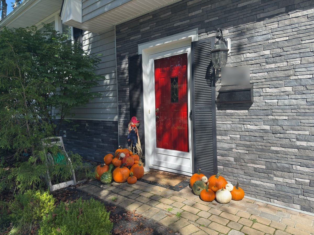 Real fall pumpkin porch display with orange and white pumpkins styled by Pascack Porches