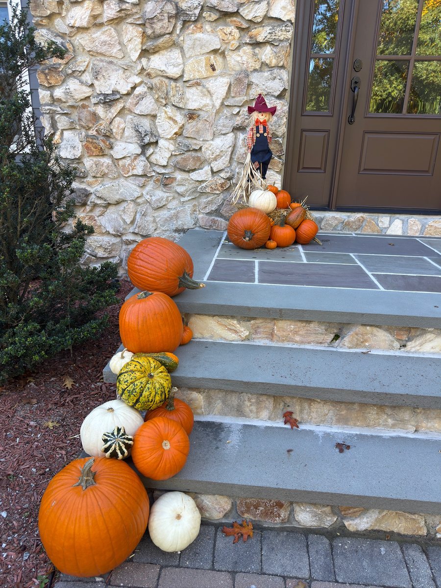 Heirloom, white, and orange pumpkins and gourds stacked up the side of stone steps
