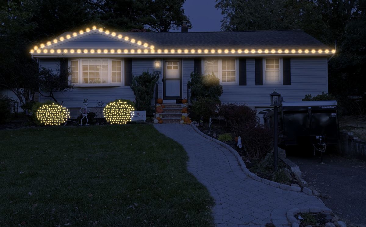Preview of the same house at night with warm white Christmas lights on the roofline and shrubs